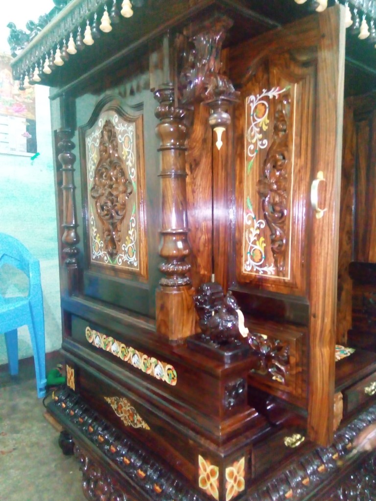 Open door of the kalasha temple, with floral inlay and a carved lion bracket